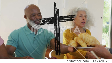 Sharing pastries, senior man wearing green polo shirt at home dining table with plate of croissants 135320373