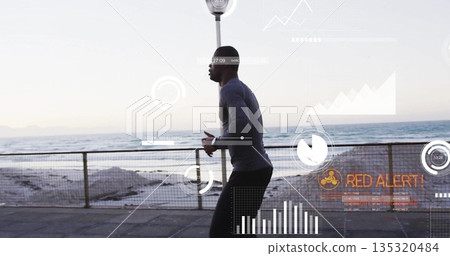 Running man sporting fitted athletic gear on waterfront path, with metal railing ocean data overlay 135320484
