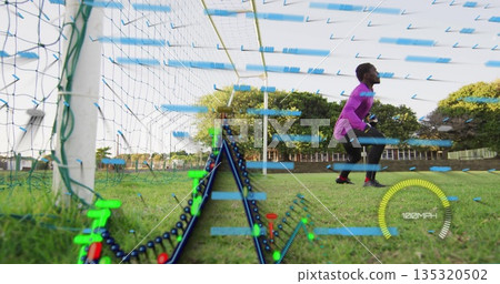Crouching goalkeeper in pink jersey defending net on turf with digital overlay, copy space Crouching goalkeeper in pink jersey defending net on turf with digital overlay, copy space 135320502