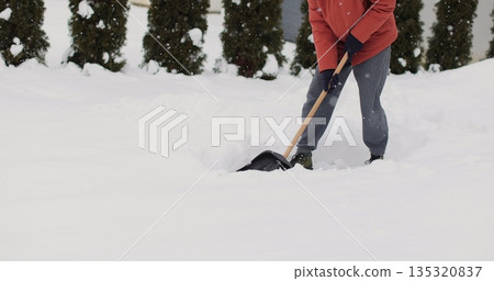 Young man cleans snow with a shovel after snowfall background of the house in winter. Young man cleans snow with a shovel after snowfall background of the house in winter. 135320837
