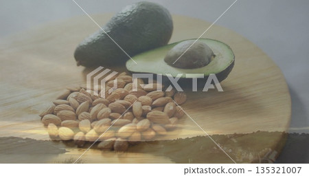 Displaying cutting board with whole avocado, halved avocado, seed, almonds in studio river sunset 135321007