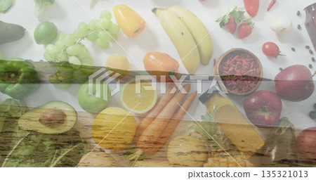 Displaying produce spread with bananas, grapes and peppers on white table, with wooden pier overlay 135321013