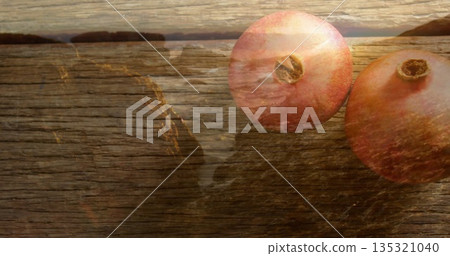 Blending ripe pomegranates with coastal overlay on weathered wooden tabletop, copy space Blending ripe pomegranates with coastal overlay on weathered wooden tabletop, copy space 135321040