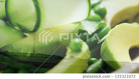 Displaying close-up of avocado slices, cucumber ribbons, green peas over fields, with wind turbine Displaying close-up of avocado slices, cucumber ribbons, green peas over fields, with wind turbine 135321072