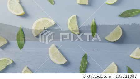 Floating citrus wedges and bay leaves forming tranquil pattern over misty lakeside water, with haze Floating citrus wedges and bay leaves forming tranquil pattern over misty lakeside water, with haze 135321098