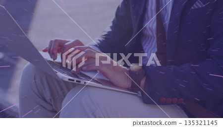 Mature Asian man wearing business attire typing on laptop in outdoor courtyard, with wristwatch Mature Asian man wearing business attire typing on laptop in outdoor courtyard, with wristwatch 135321145