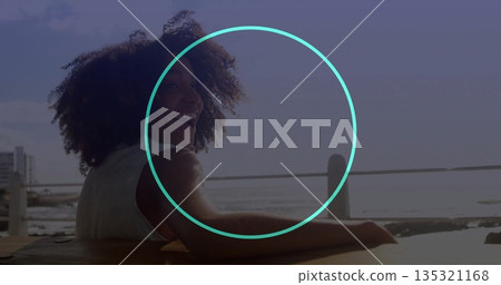 Leaning woman in sleeveless top turning head on pier, with wooden bench, metal railing, copy space 135321168