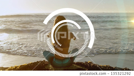 Meditating woman in turquoise leggings sitting on seaweed shore facing ocean, with digital overlay Meditating woman in turquoise leggings sitting on seaweed shore facing ocean, with digital overlay 135321292