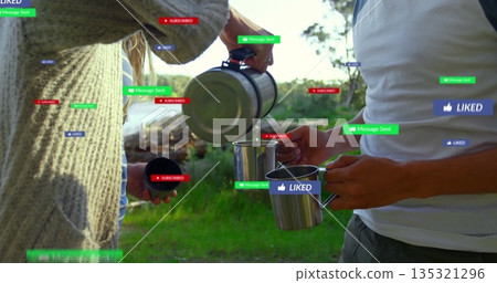 Sweater-clad woman pouring from carafe into friend's mug on lake shore, with floating notifications 135321296
