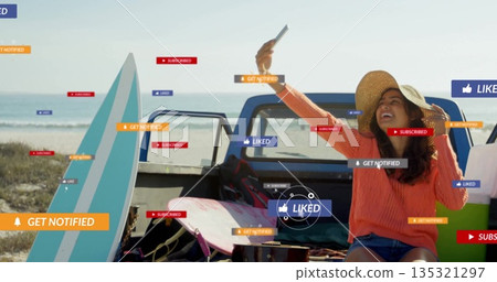 Taking selfie woman in straw hat on truck tailgate at beach, with smartphone notification icons 135321297