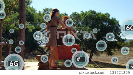 Lifting red suitcase, couple loading wooden chest on wooden deck platform, with floating 6G icons 135321299