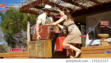 Passing couple transferring vintage suitcases on safari veranda beneath pergola, with digital icons 135321317