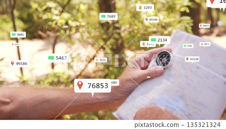 Holding paper map and compass, hiker navigating sunlit forest trail with floating digital icons 135321324