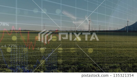 Data interface with faint hand overlaying grid and line graphs in rural field, with wind turbines Data interface with faint hand overlaying grid and line graphs in rural field, with wind turbines 135321354