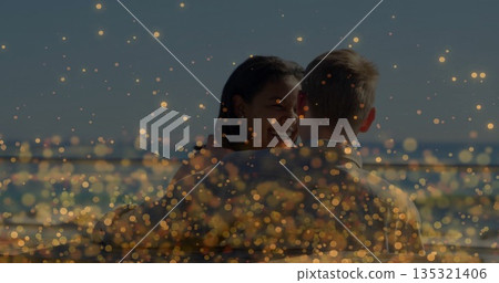 Smiling woman hugging man on waterfront deck, with metal railing and golden bokeh lights Smiling woman hugging man on waterfront deck, with metal railing and golden bokeh lights 135321406