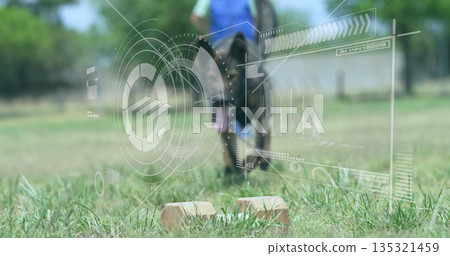 Propelling athlete in racing wheelchair in sportswear on sunlit field, with starter blocks, AR HUD 135321459