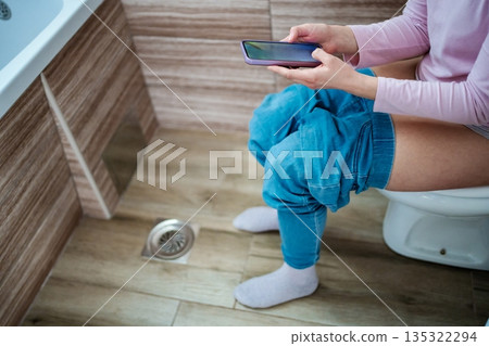 Relaxing moment in the bathroom with a smartphone in hand Relaxing moment in the bathroom with a smartphone in hand 135322294