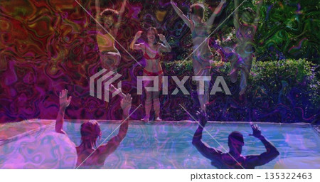 Group of friends in swimwear preparing to jump into backyard pool at night, with party lights 135322463