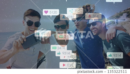 Posing friends in sunglasses and sunhat taking selfie on rocky beach, with smartphone, social icons 135322511