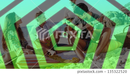 Strumming and chatting friends sitting on colorful blanket at sandy shore, with guitar and ukulele Strumming and chatting friends sitting on colorful blanket at sandy shore, with guitar and ukulele 135322520