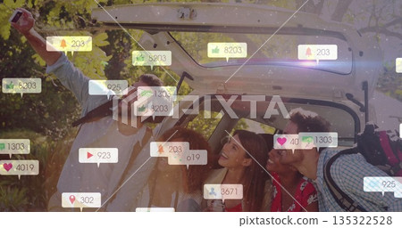 Snapping smartphone selfie group of friends leaning in woods with trunk and social media overlays 135322528
