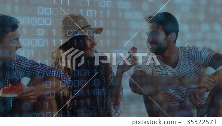 Sitting friends holding watermelon slices on stone ledge by sunny lake, with binary overlay 135322571