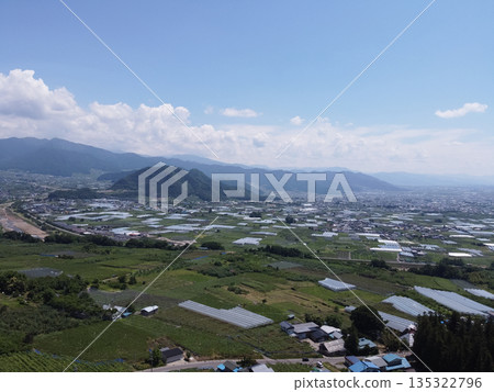 Farms and summer blue skies in Nakano City, Nagano. Majestic mountain ranges and orchards (drone aerial shot) Farms and summer blue skies in Nakano City, Nagano. Majestic mountain ranges and orchards (drone aerial shot) 135322796