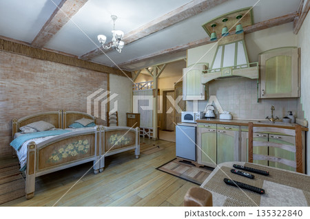 Rustic studio apartment interior with painted beds and olive kitchen 135322840