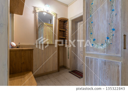 Rustic hallway interior with hand-painted wardrobe and wooden door Rustic hallway interior with hand-painted wardrobe and wooden door 135322843