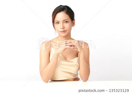 A beautiful young Asian woman with clean, fresh skin against a white background. Skincare, facial treatment, cosmetology, beauty, and spa. An elegant portrait of an Asian woman. 135323129