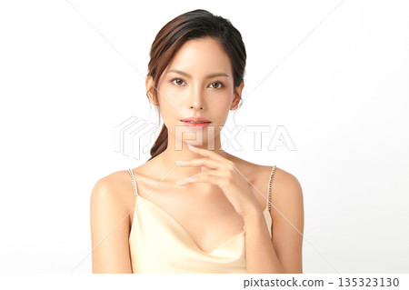 A beautiful young Asian woman with clean, fresh skin against a white background. Skincare, facial treatment, cosmetology, beauty, and spa. An elegant portrait of an Asian woman. 135323130