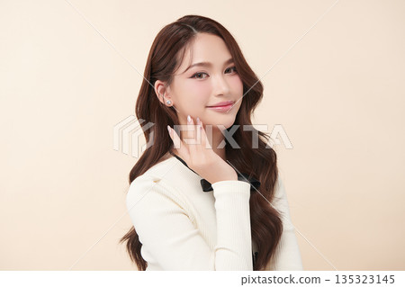 A beautiful young Asian woman with clean, fresh skin against a beige background. Skincare, facial treatment, cosmetology, beauty, and spa. An elegant portrait of an Asian woman. A beautiful young Asian woman with clean, fresh skin against a beige background. Skincare, facial treatment, cosmetology, beauty, and spa. An elegant portrait of an Asian woman. 135323145