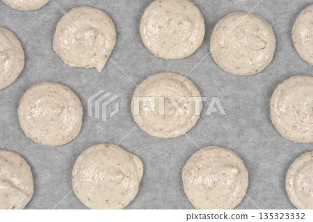 Raw french macaroons on baking paper Raw french macaroons on baking paper 135323332