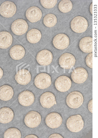 Raw french macaroons on baking paper 135323333