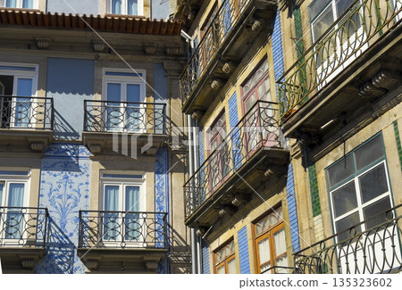 Close-up of colorful tiled facades with wrought iron balconies in Porto, Portugal. Traditional 135323602