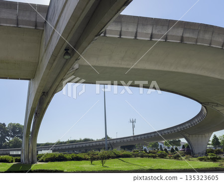 Curved concrete flyover at Porto airport with green grass landscape. Modern transport infrastructure 135323605