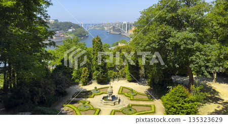 Panoramic summer view of decorative garden with Arrabida bridge and Douro river in Porto, Portugal. 135323629