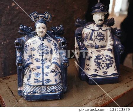 Chinese porcelain figurines of imperial couple in blue and white glaze at flea market. Vintage items. 135323879