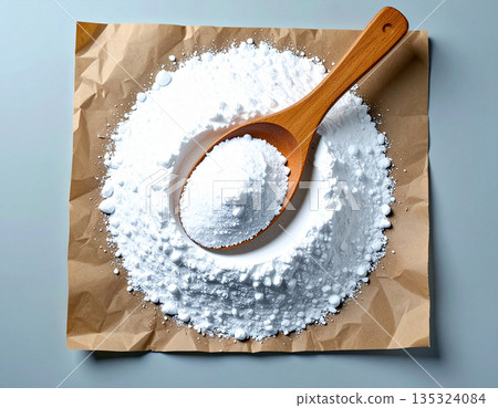 Eco product focused. Pile of powdered detergent with a wooden spoon on kraft paper on a white background. 135324084