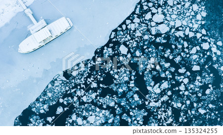 Small Boat Trapped in Ice due to Freezing of River in Winter , Aerial Shot Small Boat Trapped in Ice due to Freezing of River in Winter , Aerial Shot 135324255