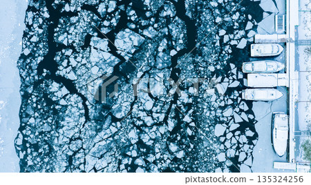 Small Boats Trapped in Ice due to Freezing of River in Winter , Aerial Shot Small Boats Trapped in Ice due to Freezing of River in Winter , Aerial Shot 135324256