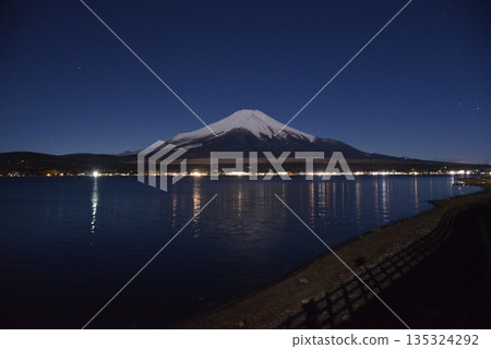 夜晚,白雪皚皚的富士山漂浮在山中湖上,夜空美不勝收。 夜晚,白雪皚皚的富士山漂浮在山中湖上,夜空美不勝收。 135324292