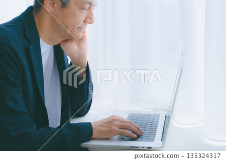 一個人在窗邊用電腦工作 135324317