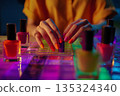 Girl doing manicure, colorful nail polish, bright table, beauty procedure 135324340