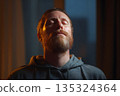 Man doing deep breathing exercises indoors, cozy light 135324364
