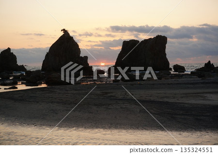 A rising sun on a bridge pile rock 135324551