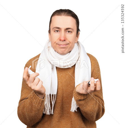 A sick man with a red nose holding two sprays and choosing a medicine is depicted on a white background. High quality photo 135324592
