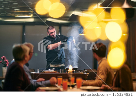 Professional Restaurant Chef Cooking Meat with Flambe Technique at Table for Guests Professional Restaurant Chef Cooking Meat with Flambe Technique at Table for Guests 135324821