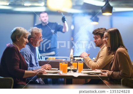 Professional Restaurant Chef Cooking Meat with Flambe Technique at Table for Guests 135324828