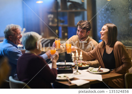 Muslim family enjoys iftar together in a warm restaurant during Ramadan celebration Muslim family enjoys iftar together in a warm restaurant during Ramadan celebration 135324856